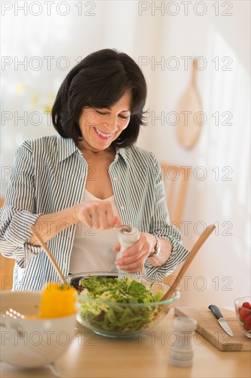 Senior woman preparing salad.