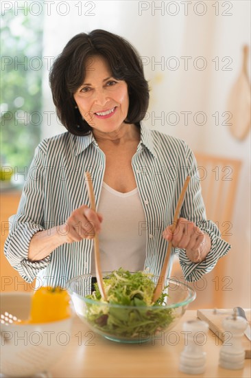 Senior woman preparing salad.