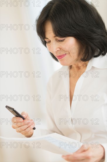 Portrait of senior businesswoman texting on mobile.
