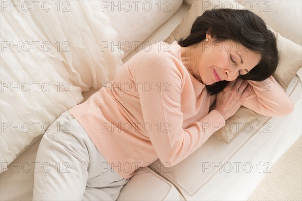 Senior woman napping on sofa.