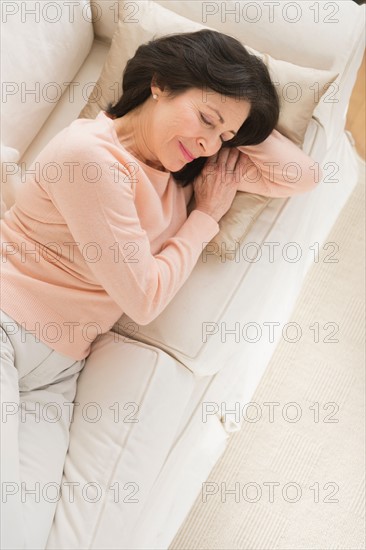 Senior woman napping on sofa.