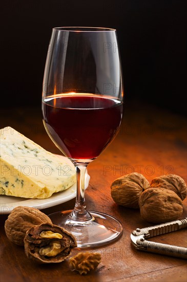 Still life with red wine, nuts and cheese.