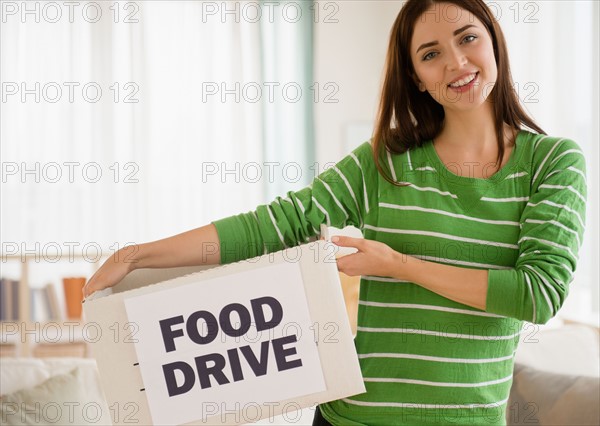 Young woman holding carton box