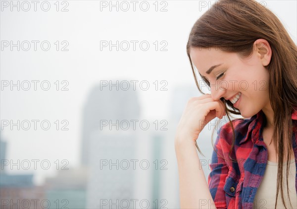 Portrait of young woman with city skyline in background