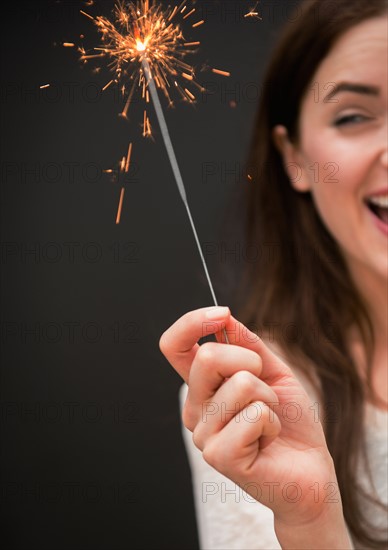 Young woman holding firework