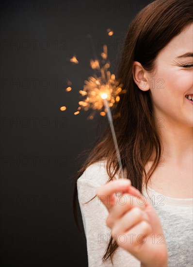 Young woman holding firework