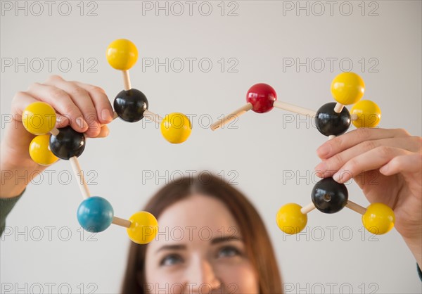 Young woman holding molecules model