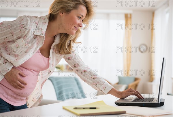 Pregnant woman using laptop