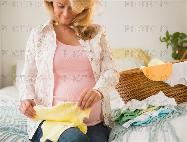 Pregnant woman folding baby clothes