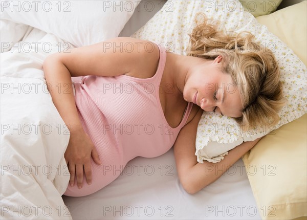 Pregnant woman asleep in bed