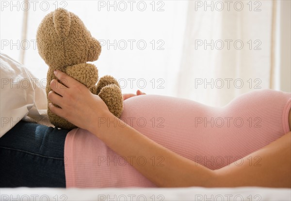 Pregnant woman holding teddy bear