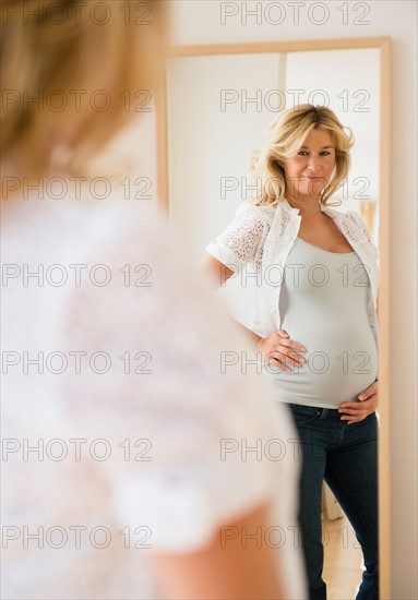 Pregnant woman looking in mirror