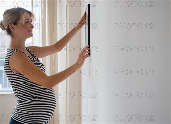 Pregnant woman decorating room