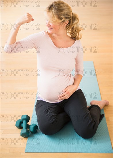 Pregnant woman exercising on mat