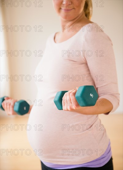 Pregnant woman exercising with dumbbell