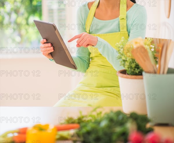 Teenage girl using digital tablet in kitchen