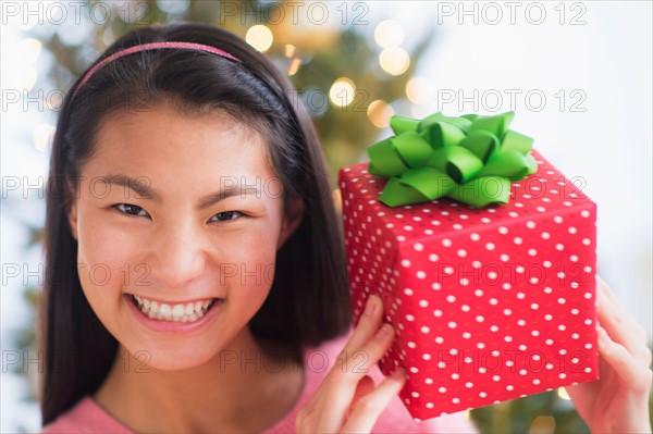 Portrait of teenage girl ( 16-17 years) holding Christmas gift