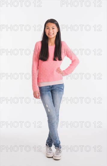Portrait of teenage girl ( 16-17 years) wearing jeans and pink sweater
