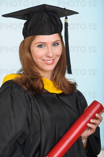 Portrait of graduate student holding diploma