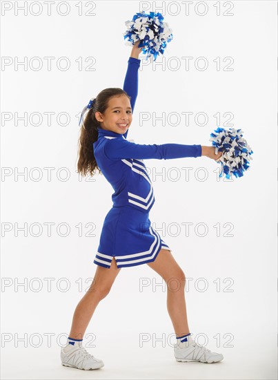 Portrait of cheerleader ( 10-11 years) holding pom-pom