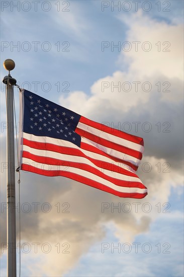 American flag in front of smoke stacks
