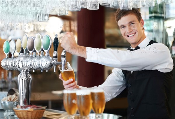 Portrait of bartender pouring beer