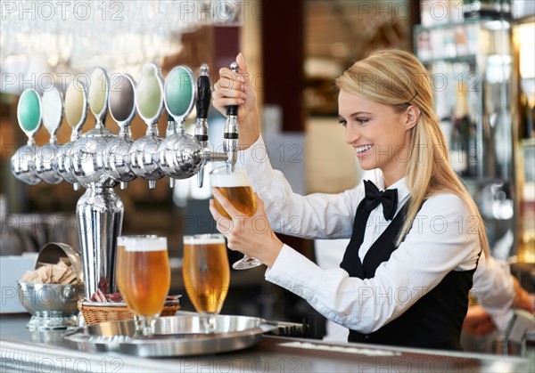 Female bartender pouring beer