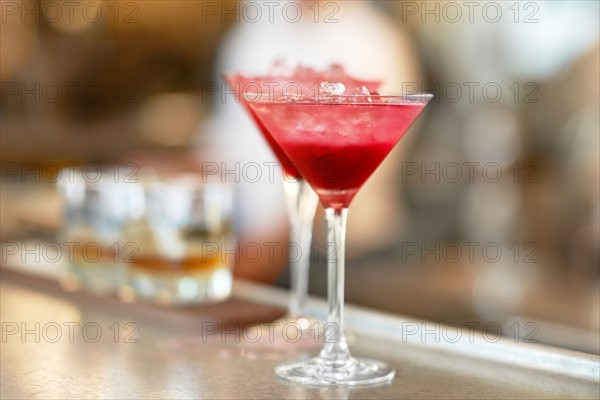 Two martini glasses standing on bar counter