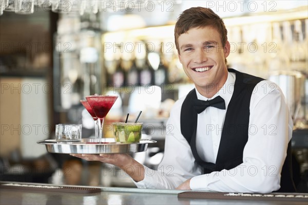 Bartender holding tray with cocktails