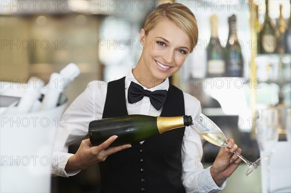 Waitress pouring champagne into champagne flute