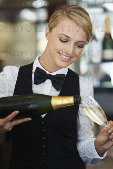 Waitress pouring champagne into champagne flute