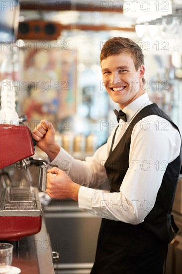 Portrait of barista standing by coffee maker