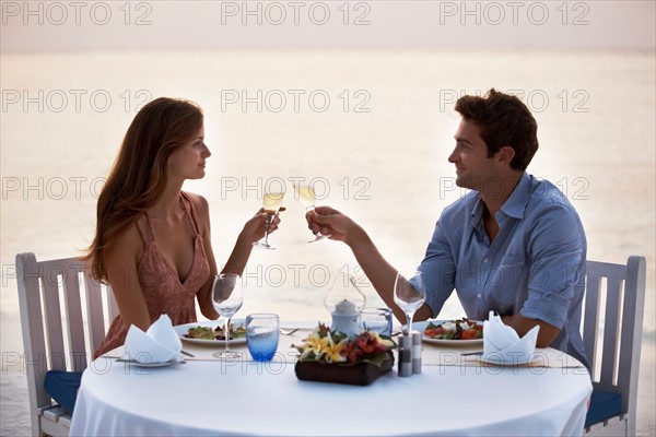 Couple eating at table on tropical beach