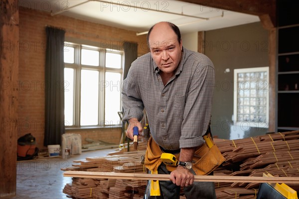 Man cutting piece of plank