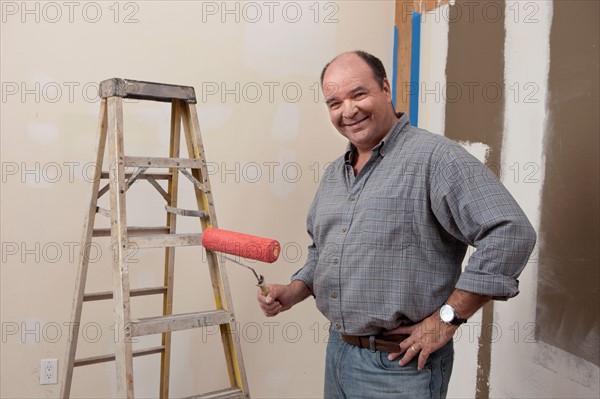 Portrait of man holding paint roller