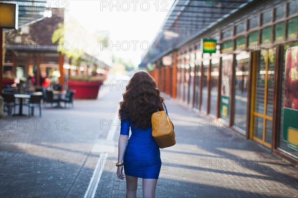 Rear view of walking elegant woman