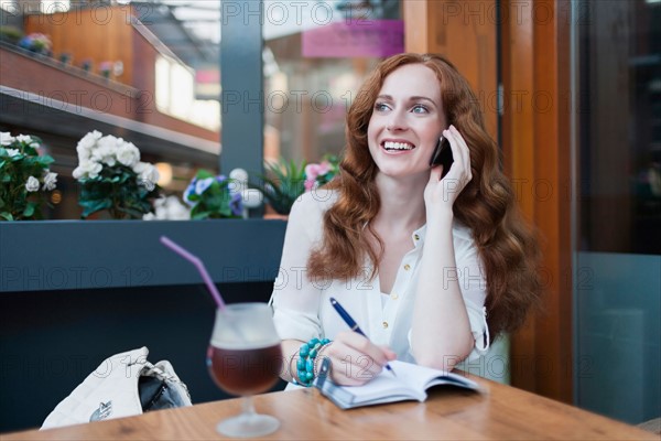 Elegant woman in cafe using mobile phone