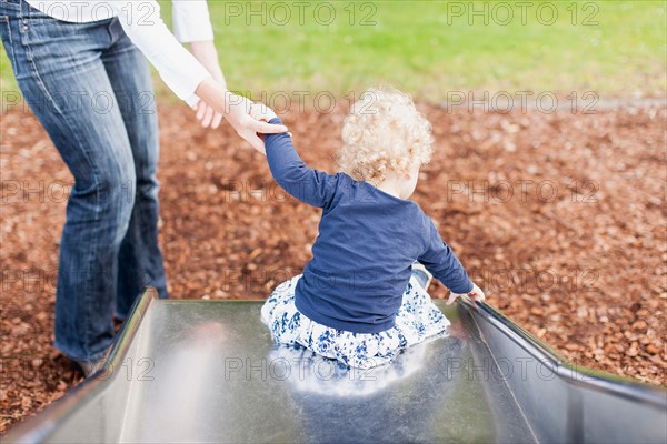 Mother with daughter (2-3) on slide