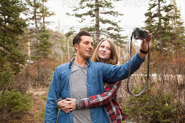 Young couple self photographing in non-urban scene