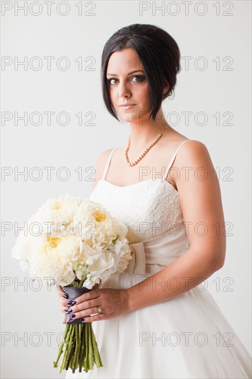 Studio Shot portrait of bride holding bouquet