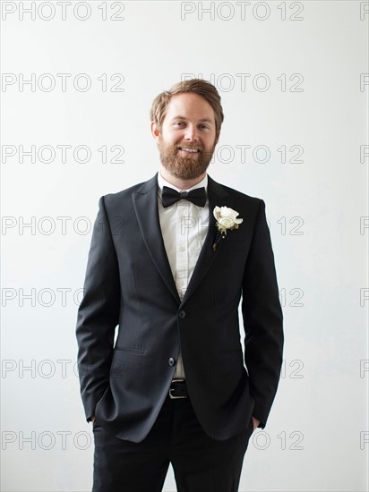 Studio Shot portrait of smiling groom with hands in pockets