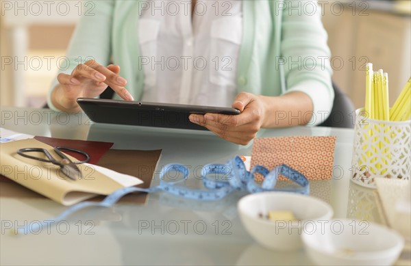 Midsection of woman using digital tablet.