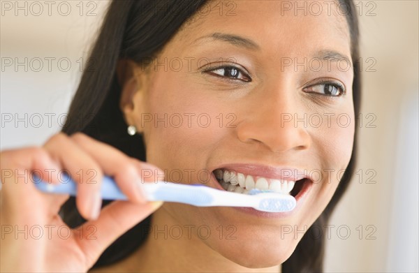 Woman brushing teeth.