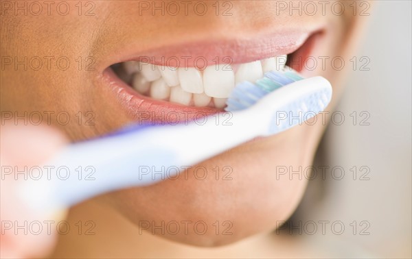 Close-up of woman brushing teeth.