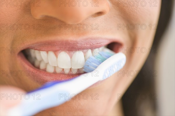 Close-up of woman brushing teeth.