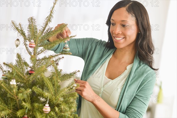 Woman decorating christmas tree.