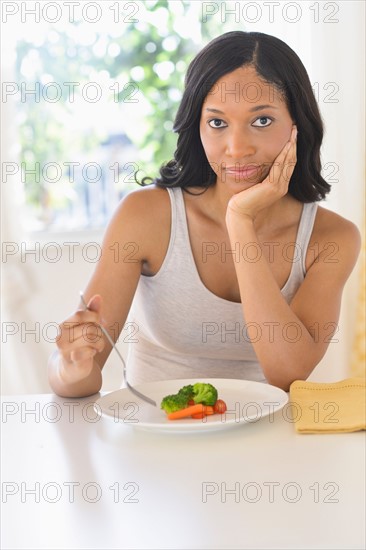 Woman eating vegetables.