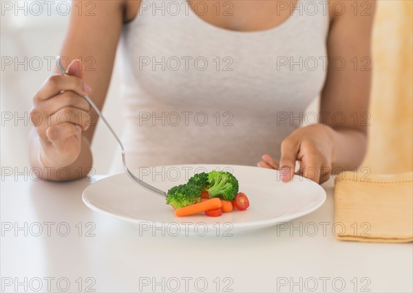 Woman eating vegetables.