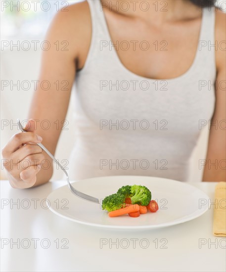 Woman eating vegetables.