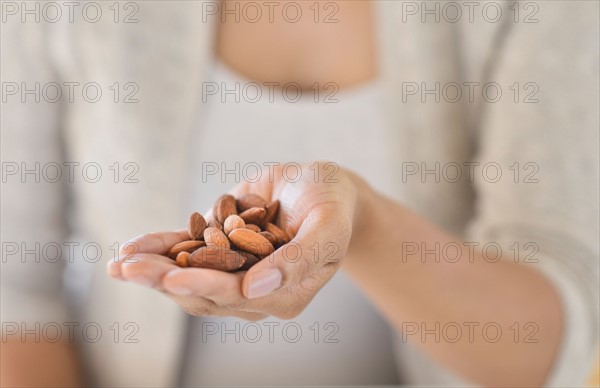 Close-up of woman holding almonds.